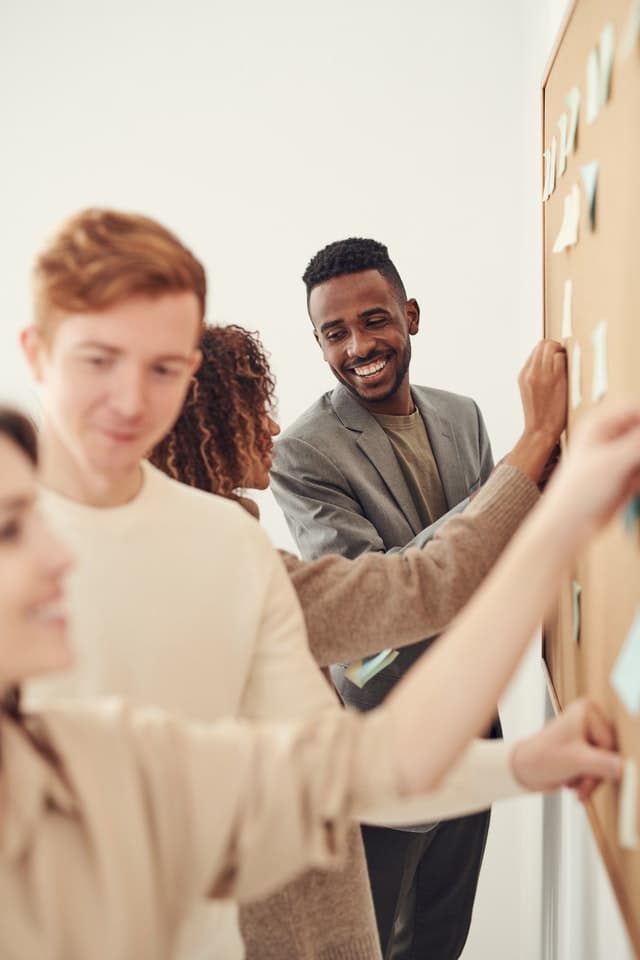 Office workers looking at post-its on the wall